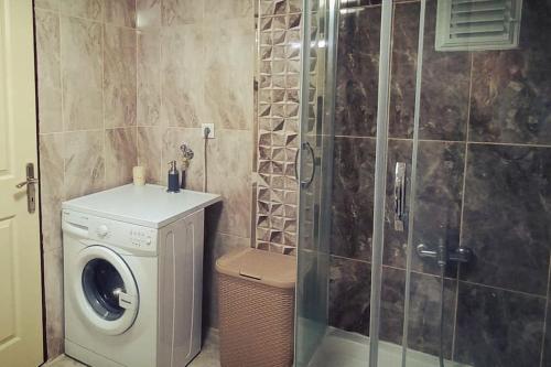 a bathroom with a shower and a washing machine at Уютная квартира в Ялове in Koruköy