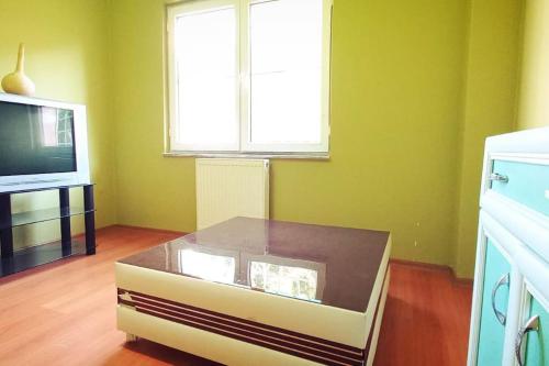 a living room with a coffee table in front of a tv at Уютная квартира в Ялове in Koruköy