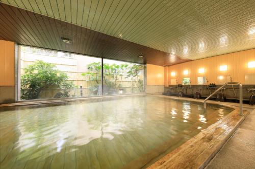 una piscina con agua en una habitación grande en 日長庵 桂月 en Hirugami