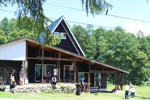 a group of people standing outside of a house at Lodge Free Run in Otari