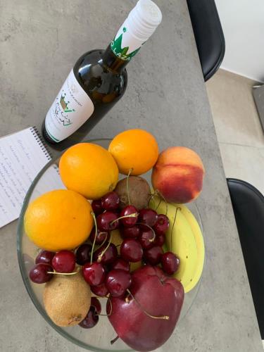 un plato de fruta en una mesa con una botella de vino en The Mousehouse, en Áno Rínglia