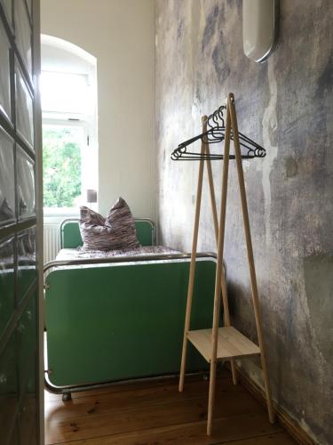 a room with a green bed and a wooden ladder at Bahnhof Nebra in Nebra