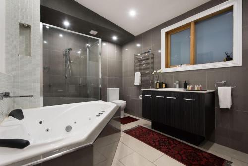 a bathroom with a large tub and a shower at Little Wombat in Daylesford