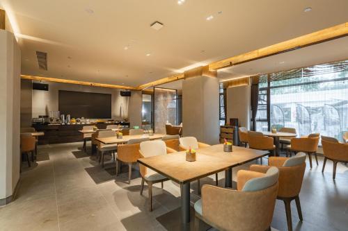 a restaurant with tables and chairs and a kitchen at Holiday Inn Express Shanghai Expo Centre, an IHG Hotel in Shanghai