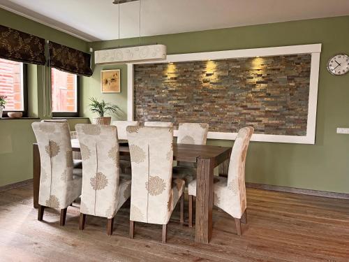 a dining room with a wooden table and chairs at Bazalt Wellness Villa in Harghita-Băi