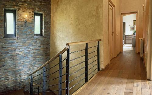 a hallway with a staircase and a brick wall at Bazalt Wellness Villa in Harghita-Băi