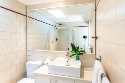 a white bathroom with a sink and a mirror at Sensom Boutique Bed and Breakfast in Coffs Harbour