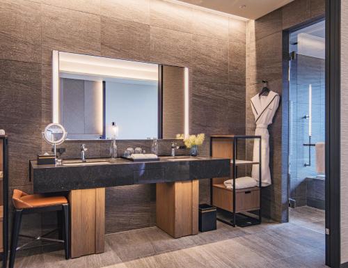 a bathroom with a large sink and a mirror at TIAD, Autograph Collection in Nagoya