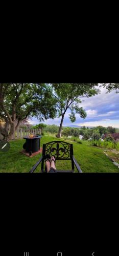 a person sitting on a bench in a park at Mountain View Lodging Cody in Cody