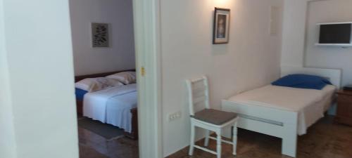 a bedroom with two beds and a desk and a chair at Apartman Nevia lka in Opric