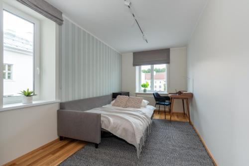 a bedroom with a bed and a desk and a window at Old town luxury penthouse apartment with Emajõgi view in Tartu