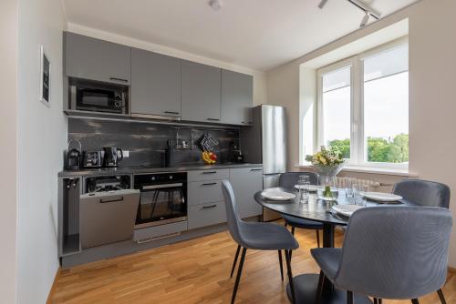 a kitchen with a table and chairs and a dining room at Old town luxury penthouse apartment with Emajõgi view in Tartu