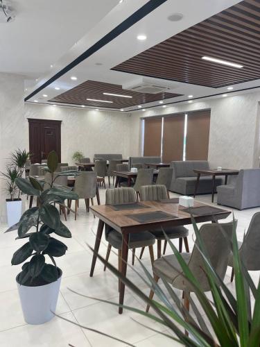 a conference room with tables and chairs and plants at Oqshom Plaza Hotel in Qarshi