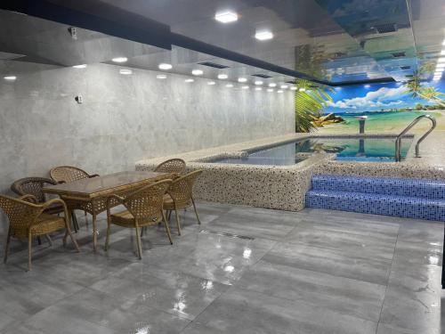 a dining room with a table and a swimming pool at Oqshom Plaza Hotel in Qarshi