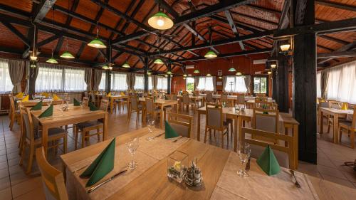 an empty restaurant with wooden tables and chairs at Bungalows Korana - Campsite Korana in Seliste Dreznicko