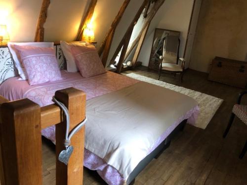 une chambre avec un grand lit et une chaise dans l'établissement La maison de César Les Eyzies de Tayac, à Sireuil