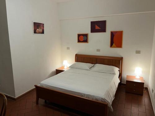 een slaapkamer met een bed en twee nachtkastjes met lampen bij Sosta Paradisa in Pisa