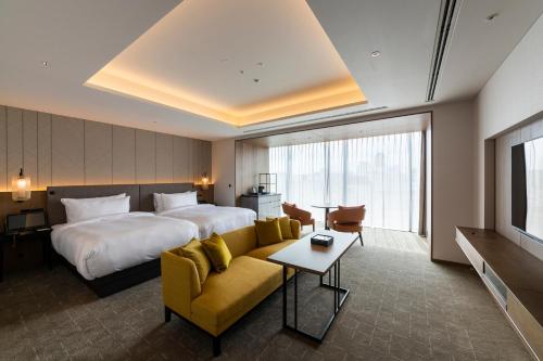 a hotel room with a bed and a couch at TIAD, Autograph Collection in Nagoya