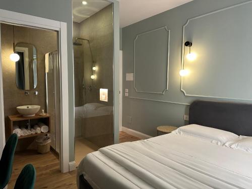 a bedroom with a bed and a bathroom with a shower at Krysos Luxury Rooms in Agrigento