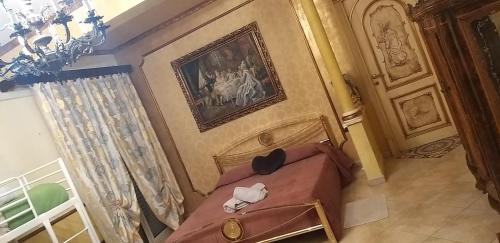 a bedroom with a bed and a painting on the wall at B&B AQUILA in Canicattì