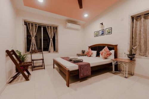 a bedroom with a bed and a table and a chair at Par-X Mist View 9A Garden Villa 3BHK in Lonavala