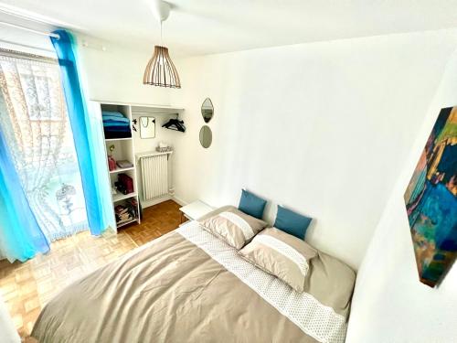 a bedroom with a bed in a room with blue curtains at Renovated Charming Apt Ideal to visit Paris in Clichy