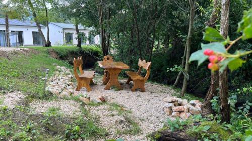 a picnic table and benches in a garden at Alpok – Spirit Apartman Park (Kőszegszerdahely) in Kőszeg