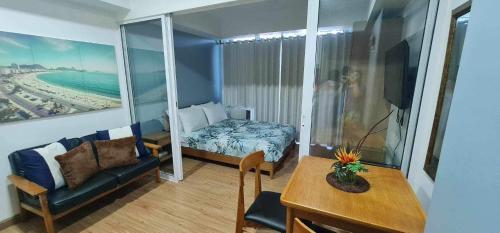 een woonkamer met een bank, een bed en een tafel bij Azure Beachview Affordable Price in Manilla
