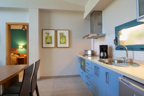 a kitchen with blue cabinets and a sink at Apartamentos Cordial Mogán Valle in Puerto de Mogán