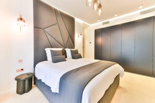 une chambre avec un grand lit avec une grande tête de lit dans l'établissement Luxueuse Villa 7 chambres avec piscine - Cannes, à Cannes