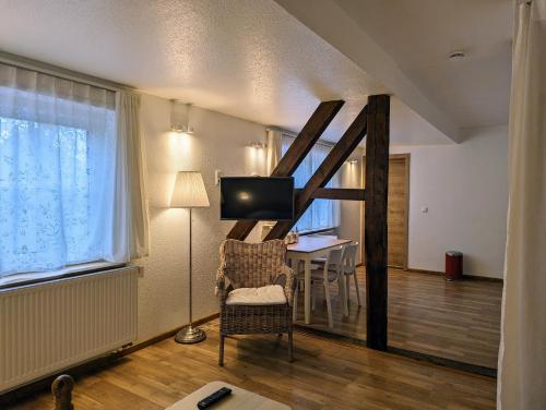 a living room with a chair and a table at Waldpension Harzer Waldwinkel in Bad Grund