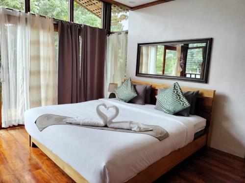 een slaapkamer met een bed met een zwaan erop bij Nivana Spa & Resort in Romblon