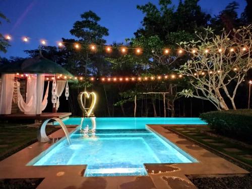 a swimming pool in a yard at night with lights at Nivana Spa & Resort in Romblon