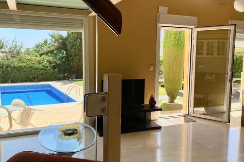 a living room with a glass table and a pool at Madrid city modern apartment in villa, free WIFI in Arroyomolinos