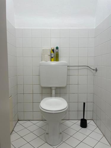 a bathroom with a toilet in a white tiled room at Ferienwohnung Sommeralm in Arzberg
