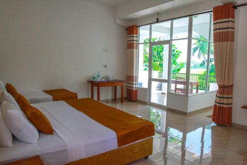sypialnia z łóżkiem i dużym oknem w obiekcie Hotel Nilketha Yala Tissamaharama w mieście Tissamaharama