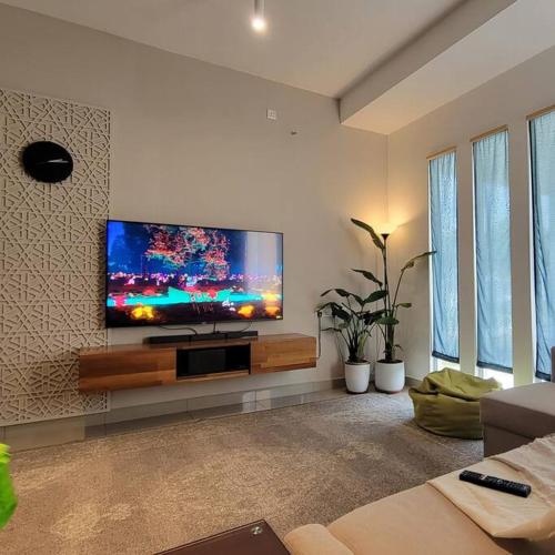a living room with a flat screen tv on a wall at LakeHomes 10 min to LEGOLAND in Gelang Patah