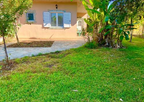 a house with a blue window and a yard at Cottage House in Amaliás