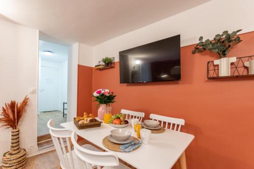 a dining room with a white table and chairs at Esope by Kleidos-Ravissant T2 en plein centre de Château-Thierry in Château-Thierry