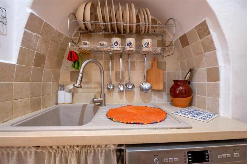 eine Küchentheke mit Spüle und Kuchen in der Unterkunft Trullo Encanto with pool in Ceglie Messapica
