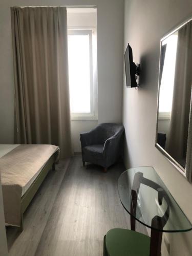 a bedroom with a bed and a chair and a glass table at La Presentosa Bed&Breakfast in Ortona