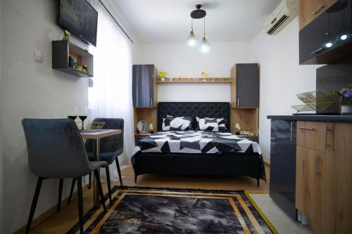 a bedroom with a bed and a table and chairs at Luxury Apartment Milićević 2 in Trebinje