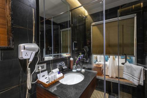 a bathroom with a sink and a phone in it at Clarion Hotel Dehradun in Dehradun