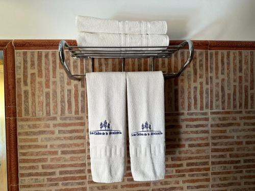 um grupo de toalhas num toalheiro na casa de banho em Hotel Restaurante Los Caños de la Alcaiceria em Alhama de Granada