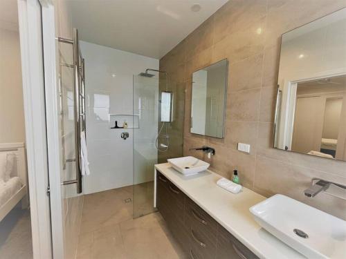 a bathroom with a sink and a shower and a mirror at Ocean Escape Esperance in Esperance