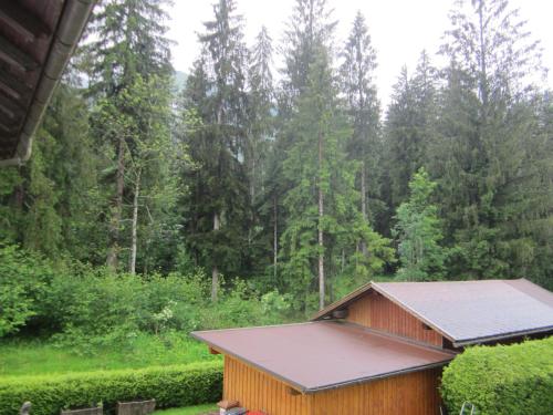a barn with a solar roof in a forest at Apartmenthaus Kestel Gasthof in Kirchbach