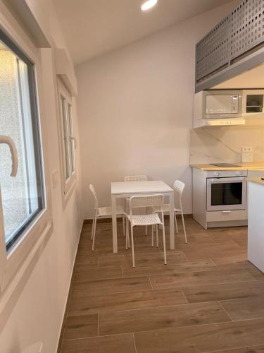 a kitchen with a table and chairs in a room at Miniloft Baiona COM I in Baiona