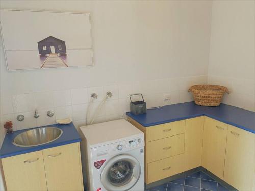 a small kitchen with a sink and a washing machine at The Oceanaire in Esperance
