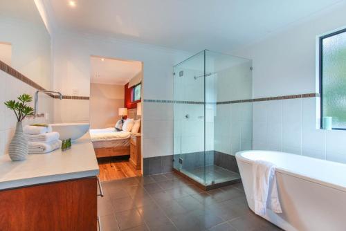 a bathroom with a tub and a glass shower at Shumadia I Private Properties in Yallingup Siding