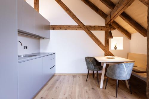 eine Küche mit einem Tisch und Stühlen im Zimmer in der Unterkunft Ansitz Layshof Apartment 1254 in Meran